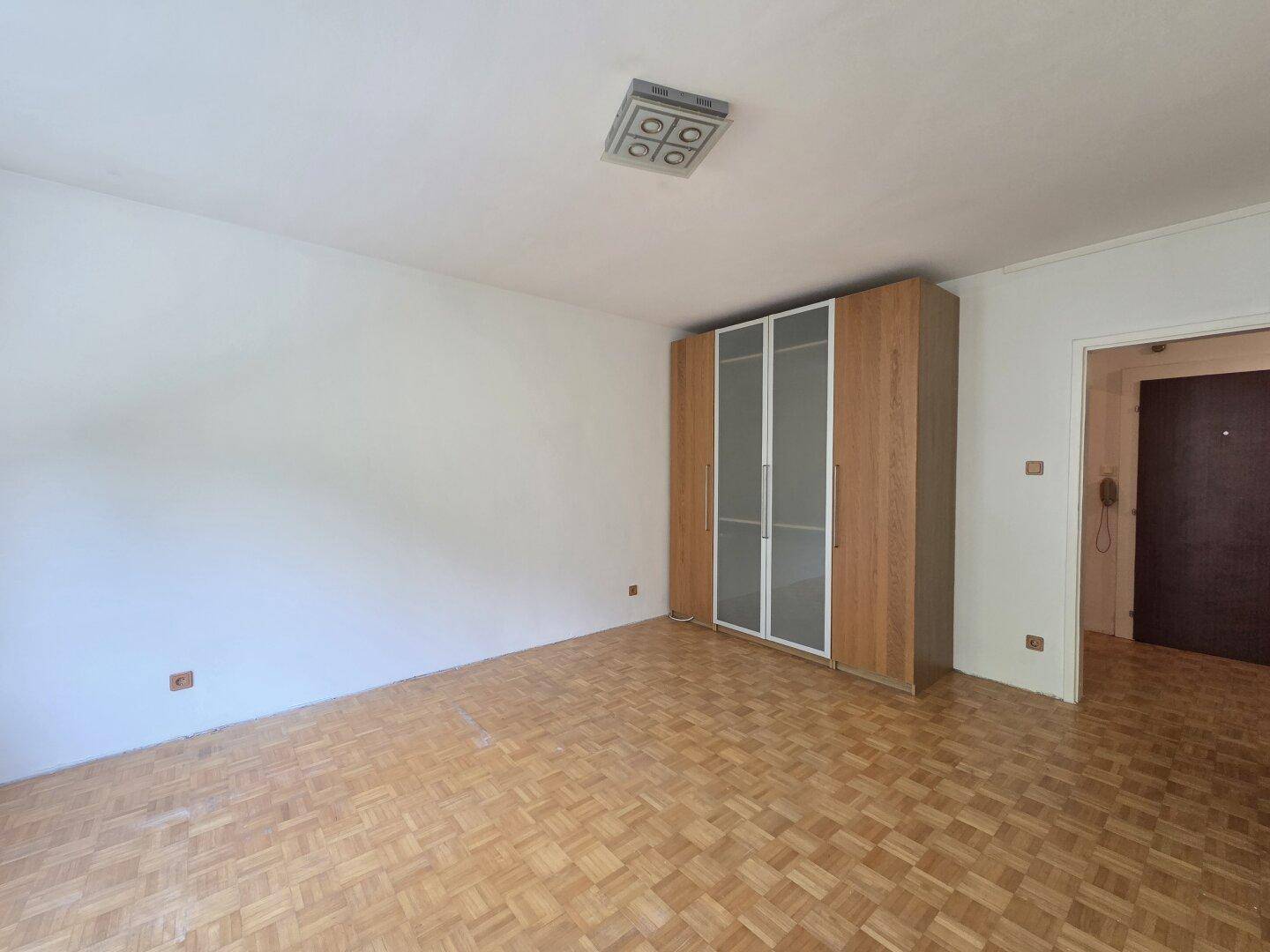 Schlafzimmer mit Parkettboden und großem Kleiderschrank, bietet viel Stauraum.