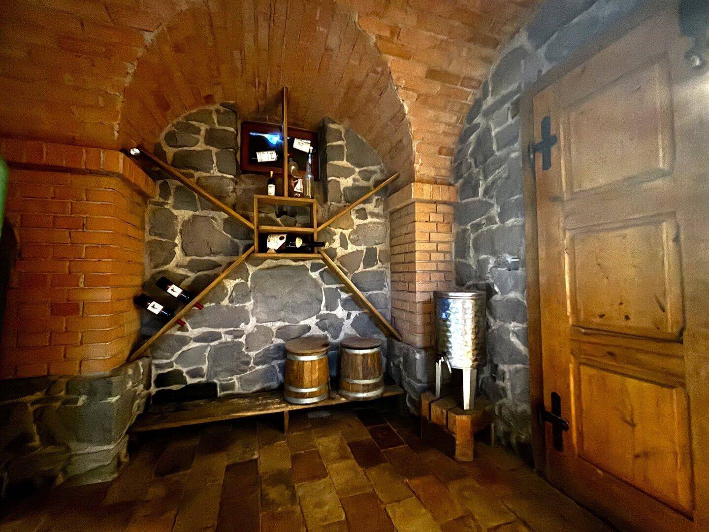 Authentischer Weinkeller mit rustikalen Steinwänden, Ziegelgewölbe und traditionellen Weinregalen.