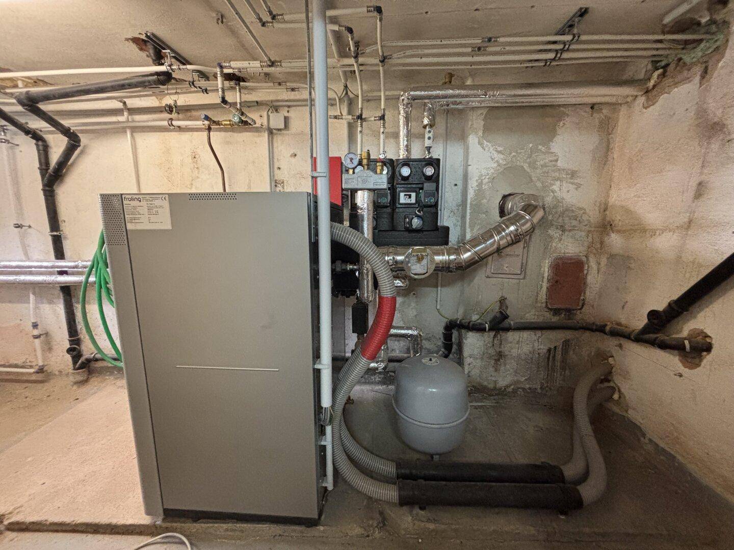 Heizungsanlage im Keller mit Rohren und technischen Installationen, funktionaler Raum.