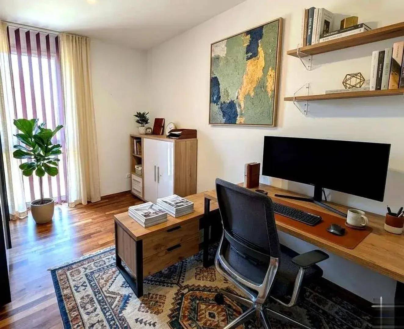 Helles Arbeitszimmer mit Holzboden, Schreibtisch und Bücherregalen.