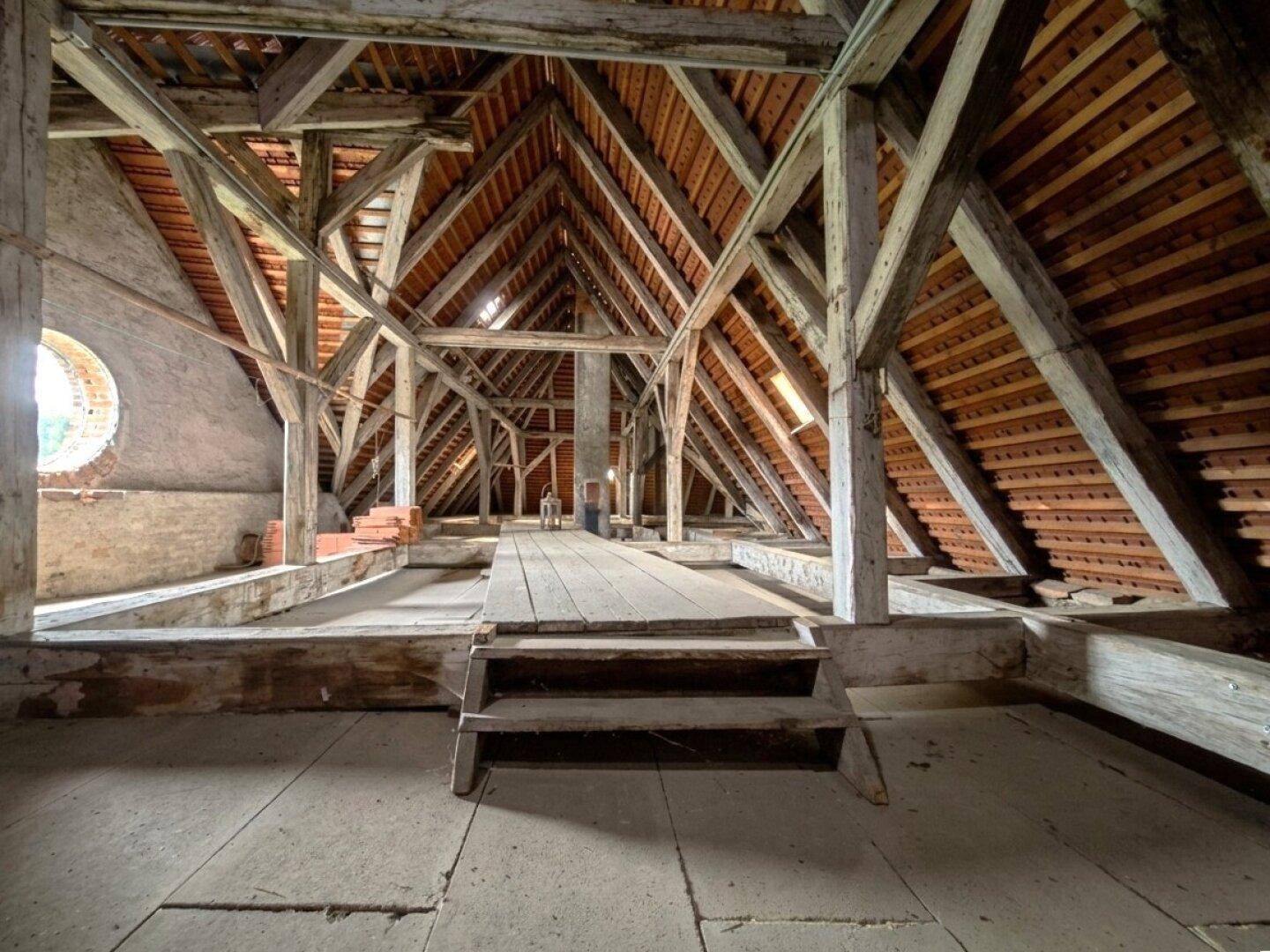 Geräumiger Dachboden mit freiliegenden Holzbalken und Dachkonstruktion, bereit für den Ausbau.