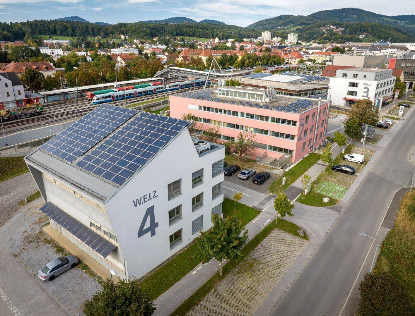 Luftaufnahme eines Innovationszentrums mit mehreren Gebäuden und Solaranlagen auf den Dächern.