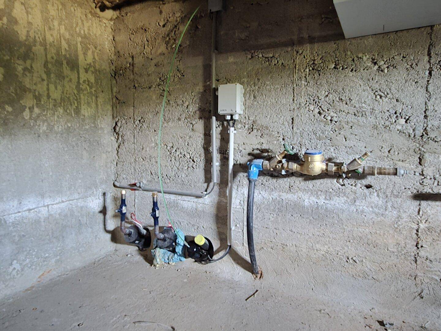 Kellerraum mit Wasserinstallationen und Pumpen, bereit für den Anschluss.