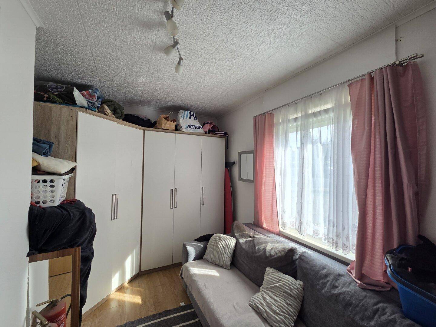 Kinderzimmer oder Gästezimmer mit Schrankwand und Sofa.
