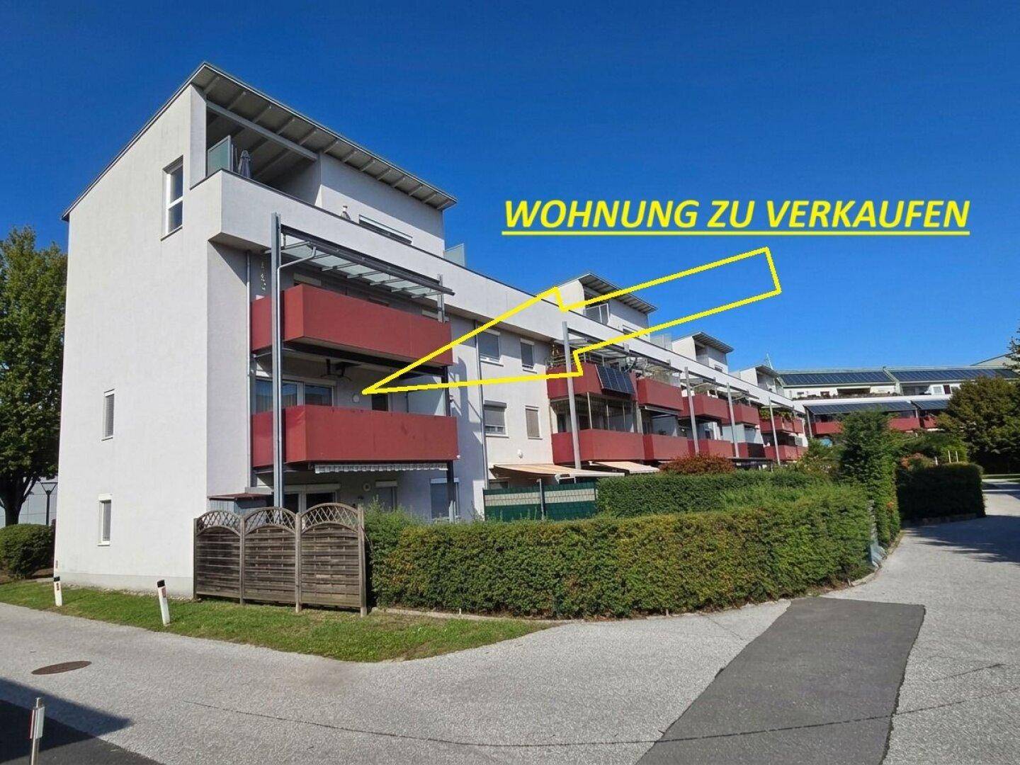Mehrfamilienhaus mit Balkonen und grüner Umgebung, Wohnung zum Verkauf markiert.