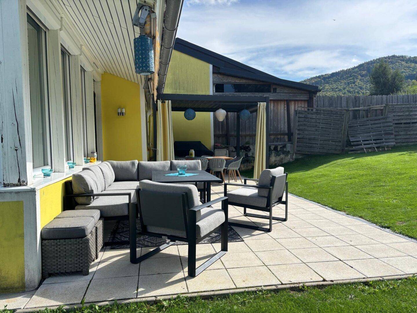 Gemütlicher Loungebereich auf der Terrasse mit Blick auf den Garten und die umliegende Natur.