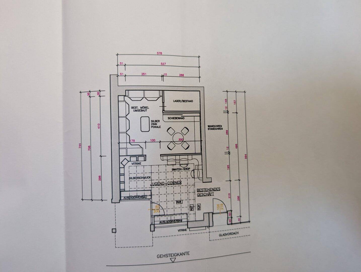Grundriss eines Geschäftsraums mit verschiedenen Zonen und Thekenbereich im Erdgeschoss.