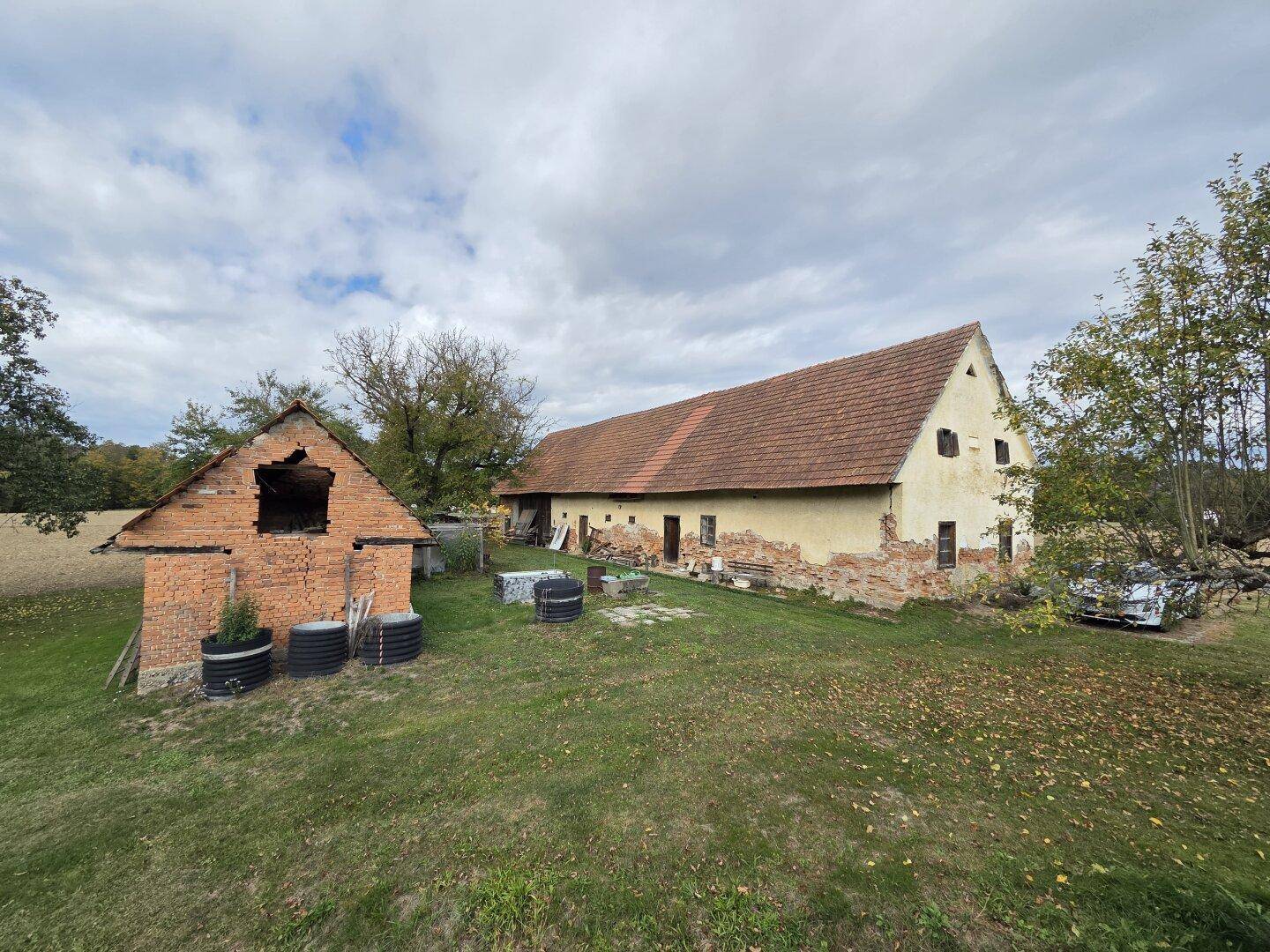 Gesamtansicht des Landhauses und des Backsteingebäudes auf einem weitläufigen Grundstück.
