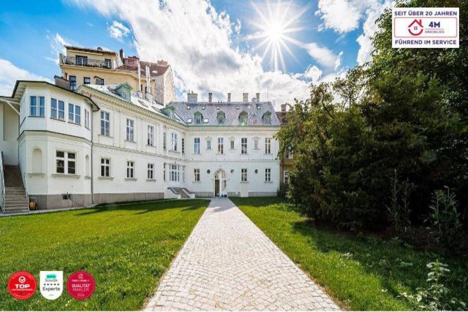 Majestätisches Gebäude mit langer gepflasterter Zufahrt und sonnigem Himmel.
