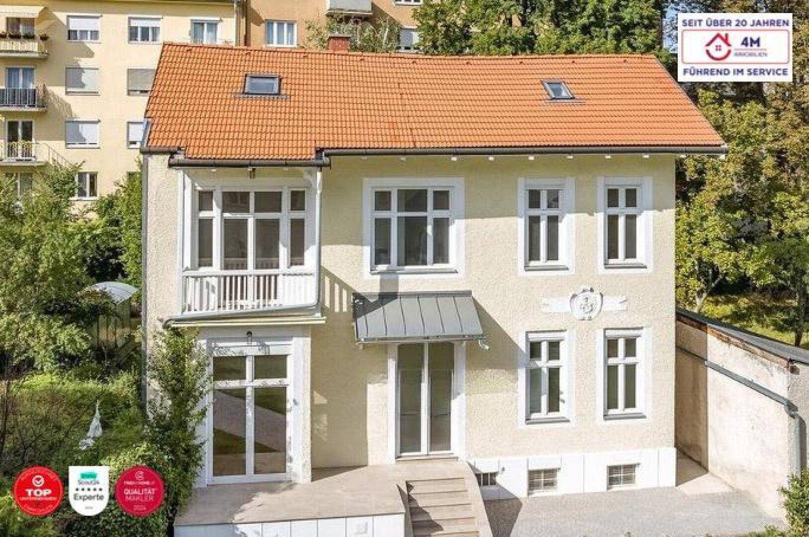 Charmantes Einfamilienhaus mit orangefarbenem Ziegeldach und kleinem Balkon.