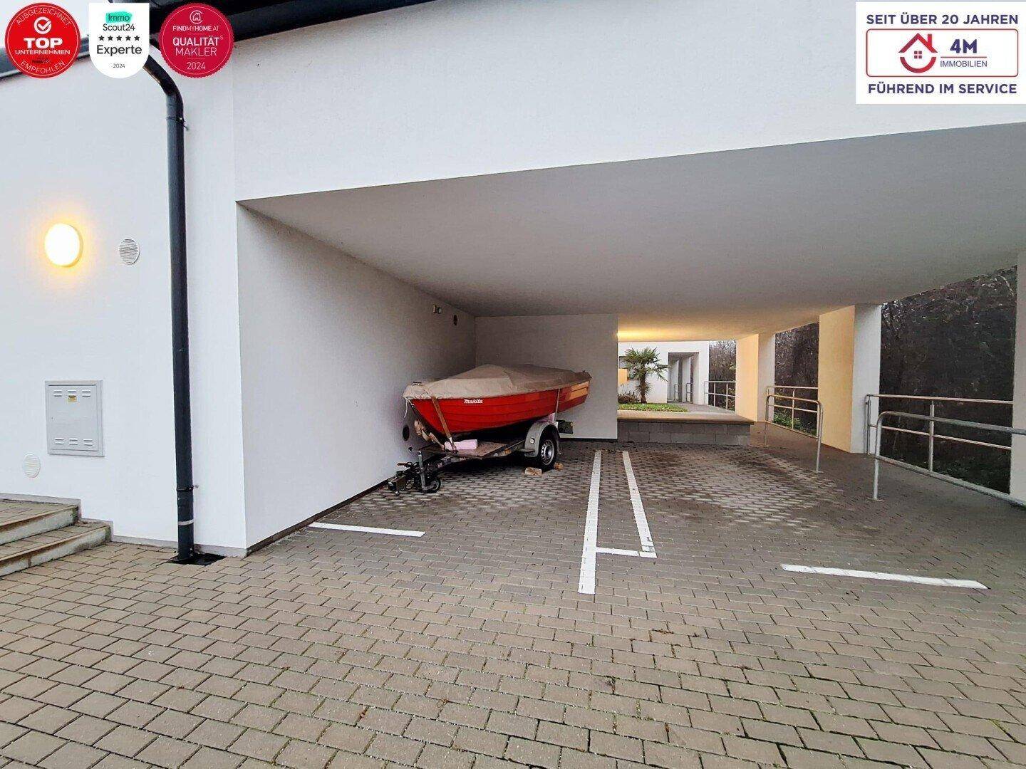 Überdachter Parkplatz mit einem Boot auf einem Anhänger, bietet Schutz für Fahrzeuge.