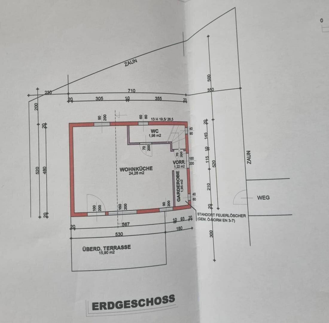 Grundriss des Erdgeschosses mit Wohnküche, WC und überdachter Terrasse.
