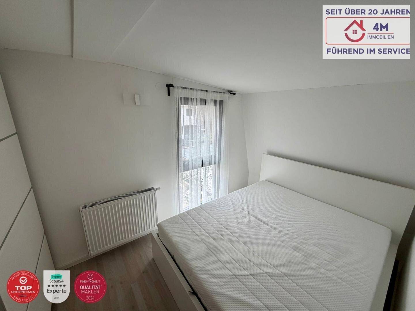 Gemütliches Schlafzimmer mit Bett, Heizung und Fenster für natürliches Licht.