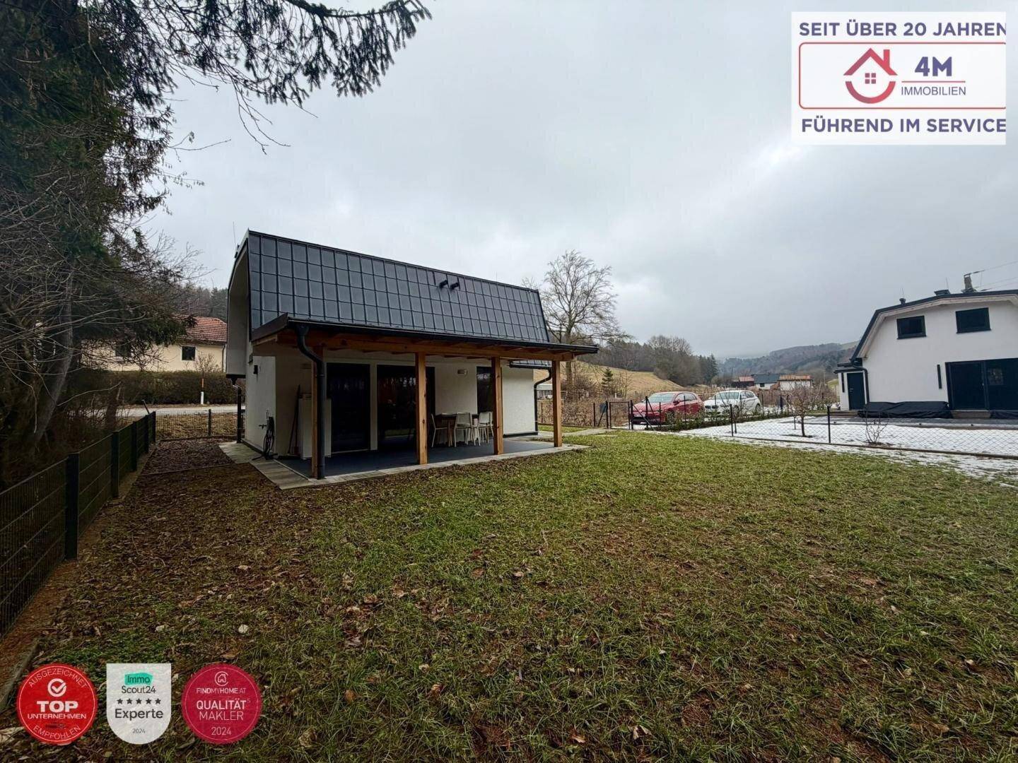Weitläufiger Gartenbereich mit Rasenfläche und Blick auf das moderne Einfamilienhaus.