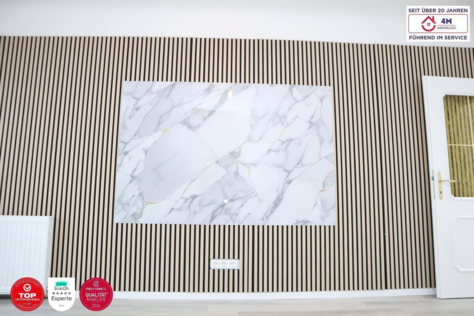 Nahaufnahme der modernen Akzentwand mit Holzlatten und eleganter Marmor-Optik.