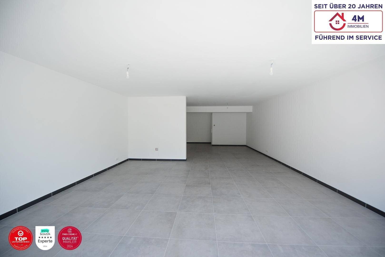 Großer, leerer Innenraum mit weißen Wänden und modernem Fliesenboden, bereit für individuelle Gestaltung.
