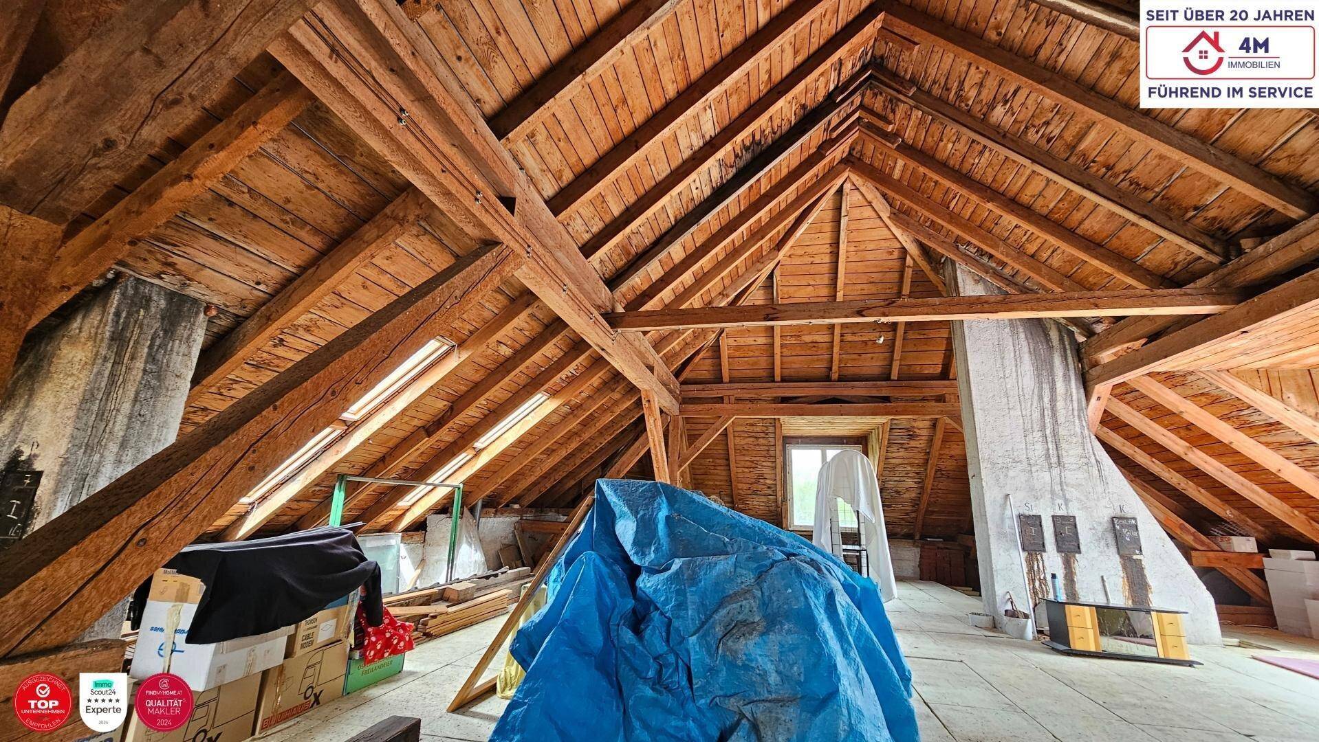 Geräumiger Dachboden mit sichtbaren Holzbalken und viel Stauraum unter dem Dach.