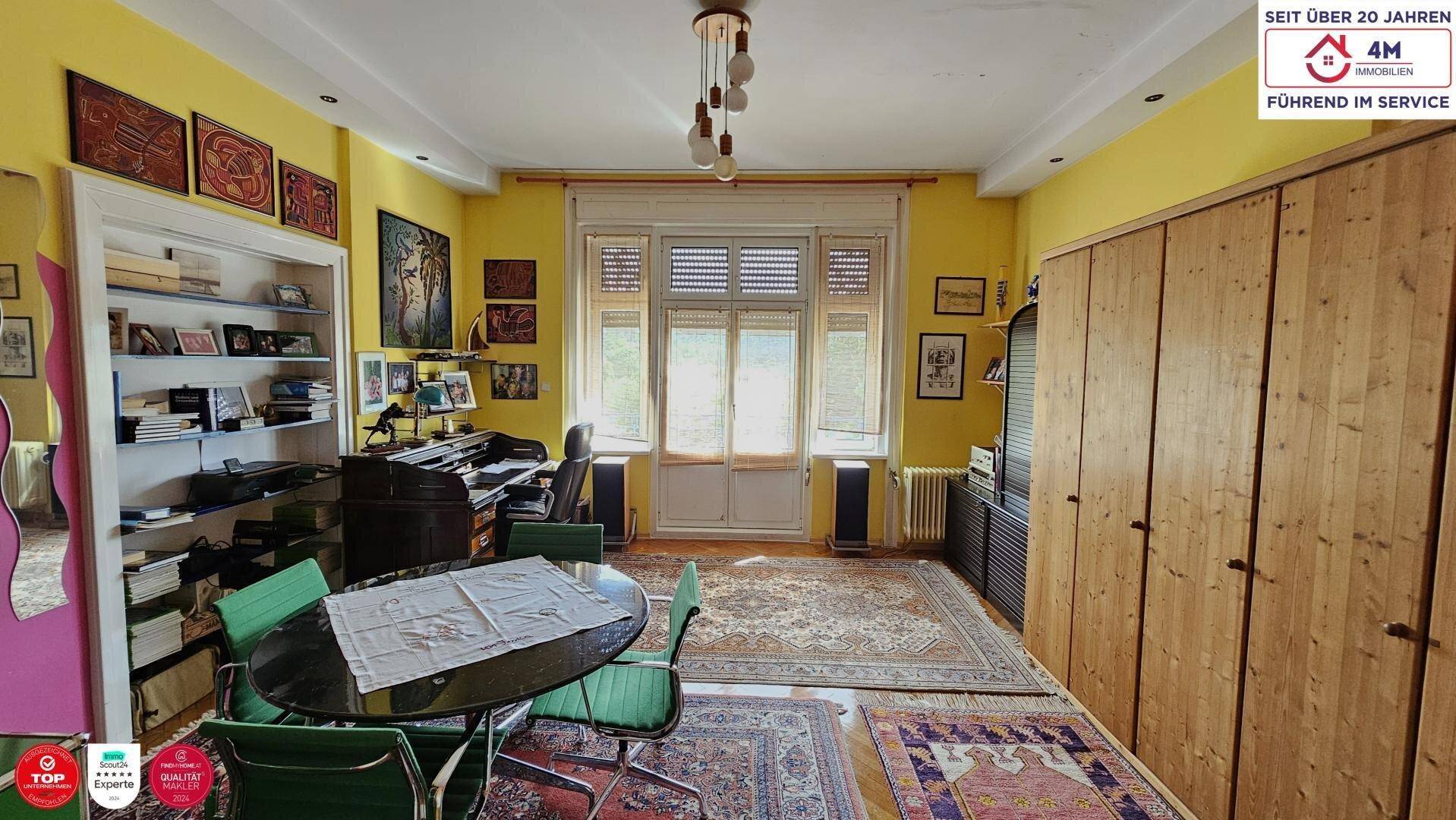 Helles Esszimmer mit gelben Wänden, Holzeinbauschränken und einem runden Esstisch.