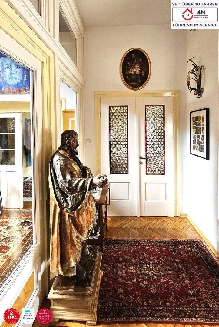 Eleganter Flur mit Parkettboden, einer großen Statue und traditionellen Türen.