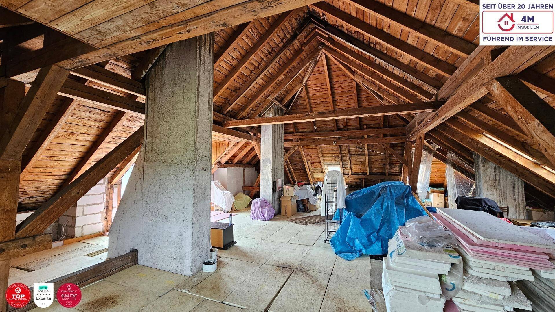 Großer Dachboden mit freiliegenden Holzbalken und Betonstützen, ideal für Ausbau.