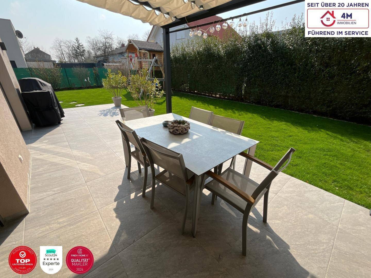 Geräumige Terrasse mit Essbereich im Freien und Blick auf den gepflegten Garten.