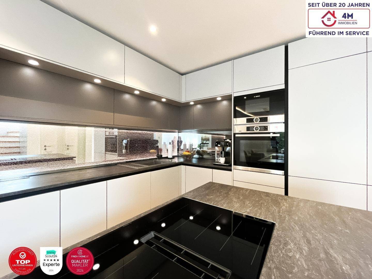 Hochmoderne Einbauküche mit Induktionskochfeld, Backofen und eleganten Schränken.