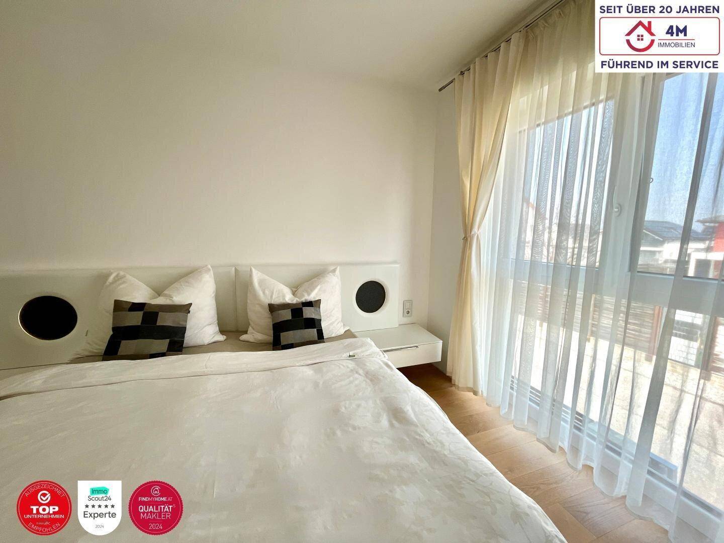 Gemütliches Schlafzimmer mit großem Fenster, das viel Tageslicht hereinlässt.