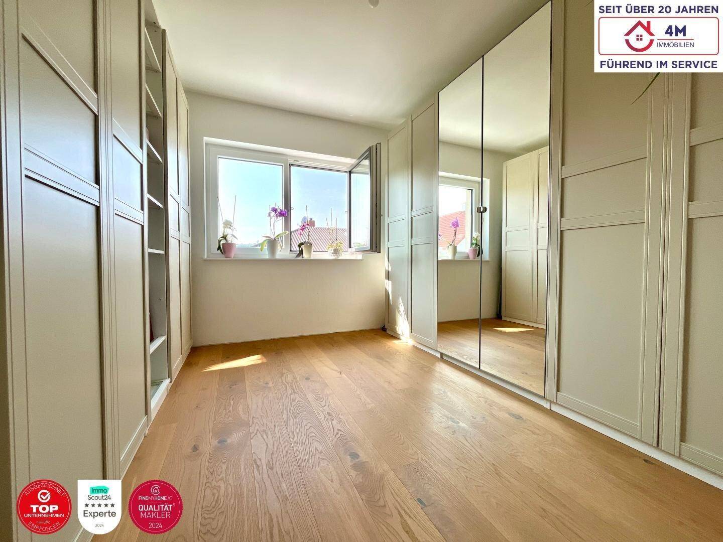 Geräumiges Ankleidezimmer mit maßgefertigten Einbauschränken und Fenster für Tageslicht.