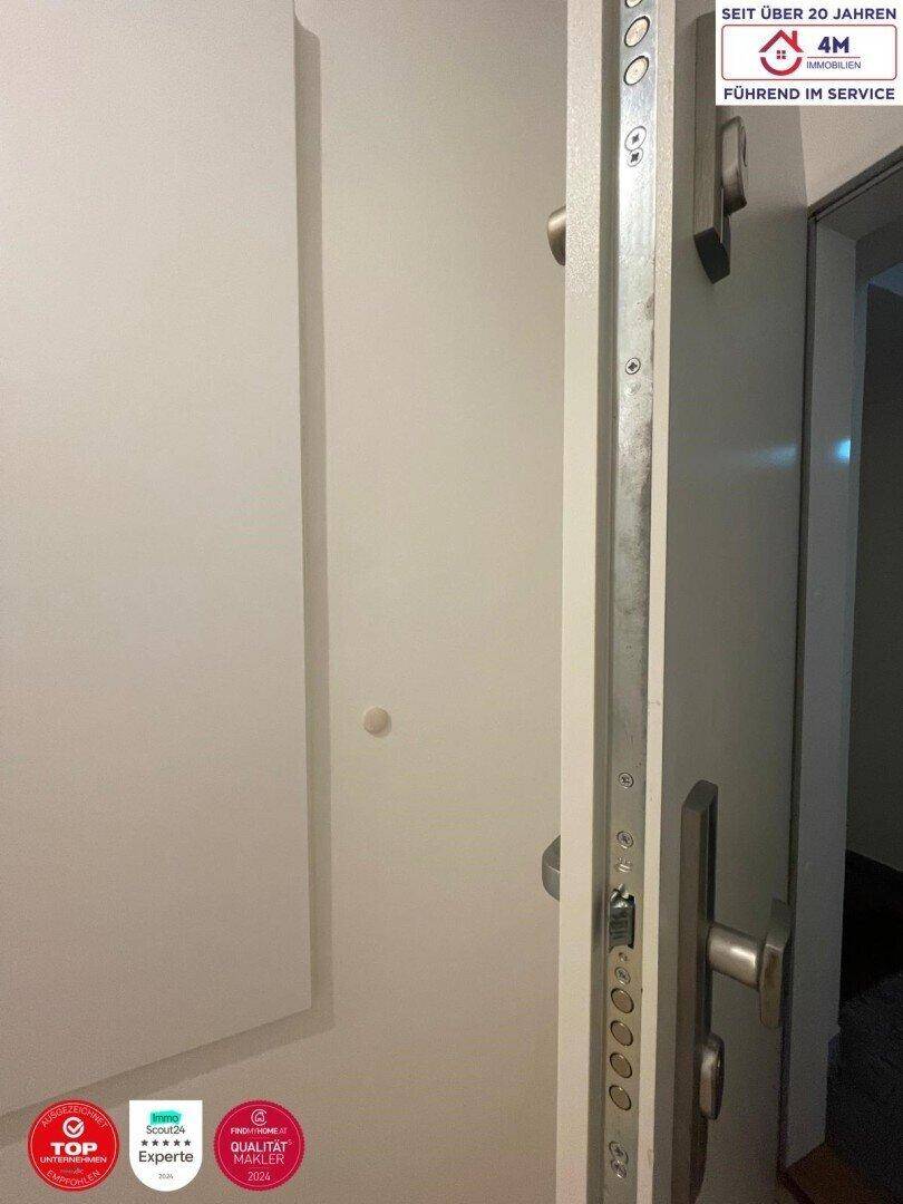 Nahaufnahme einer Sicherheitstür mit Mehrfachverriegelung, die den Eingangsbereich schützt.