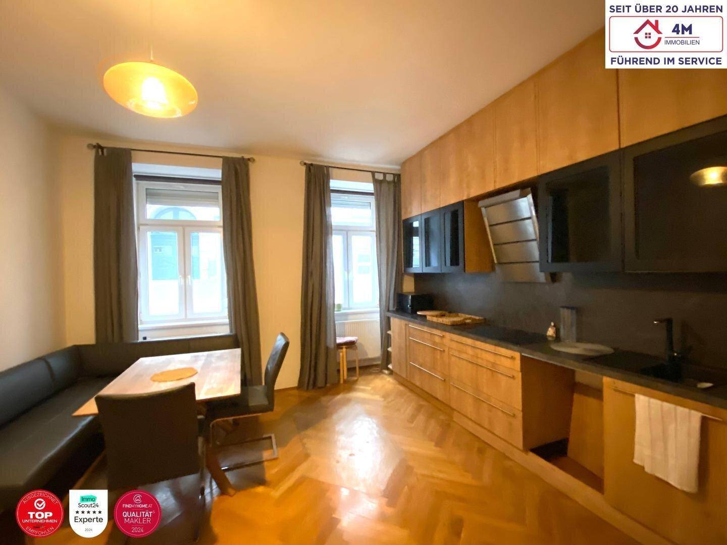 Helle Küche mit Holzakzenten, Essbereich und modernen Einbaugeräten.