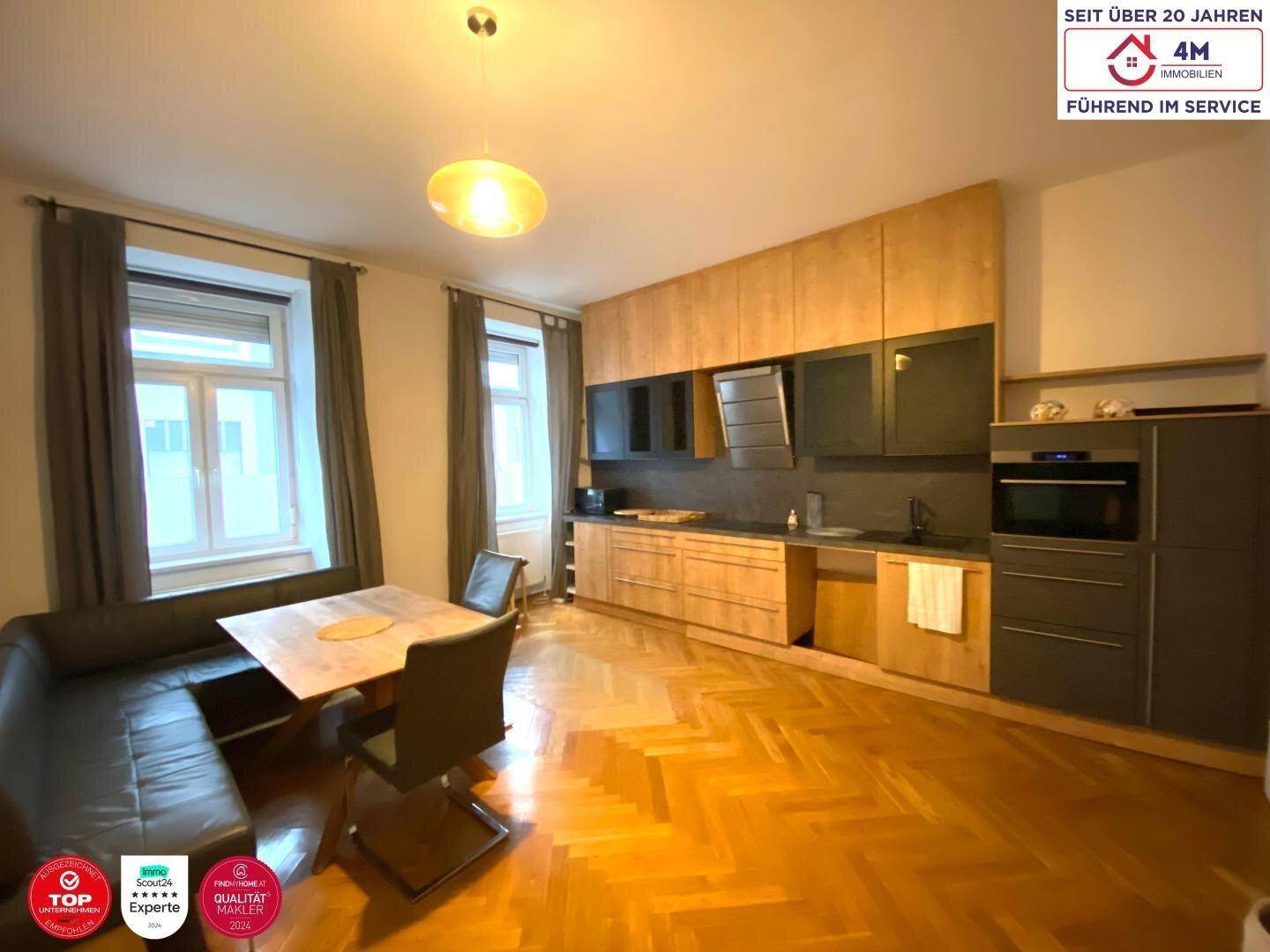 Moderne Wohnküche mit Holzelementen, Essbereich und integrierten Geräten.