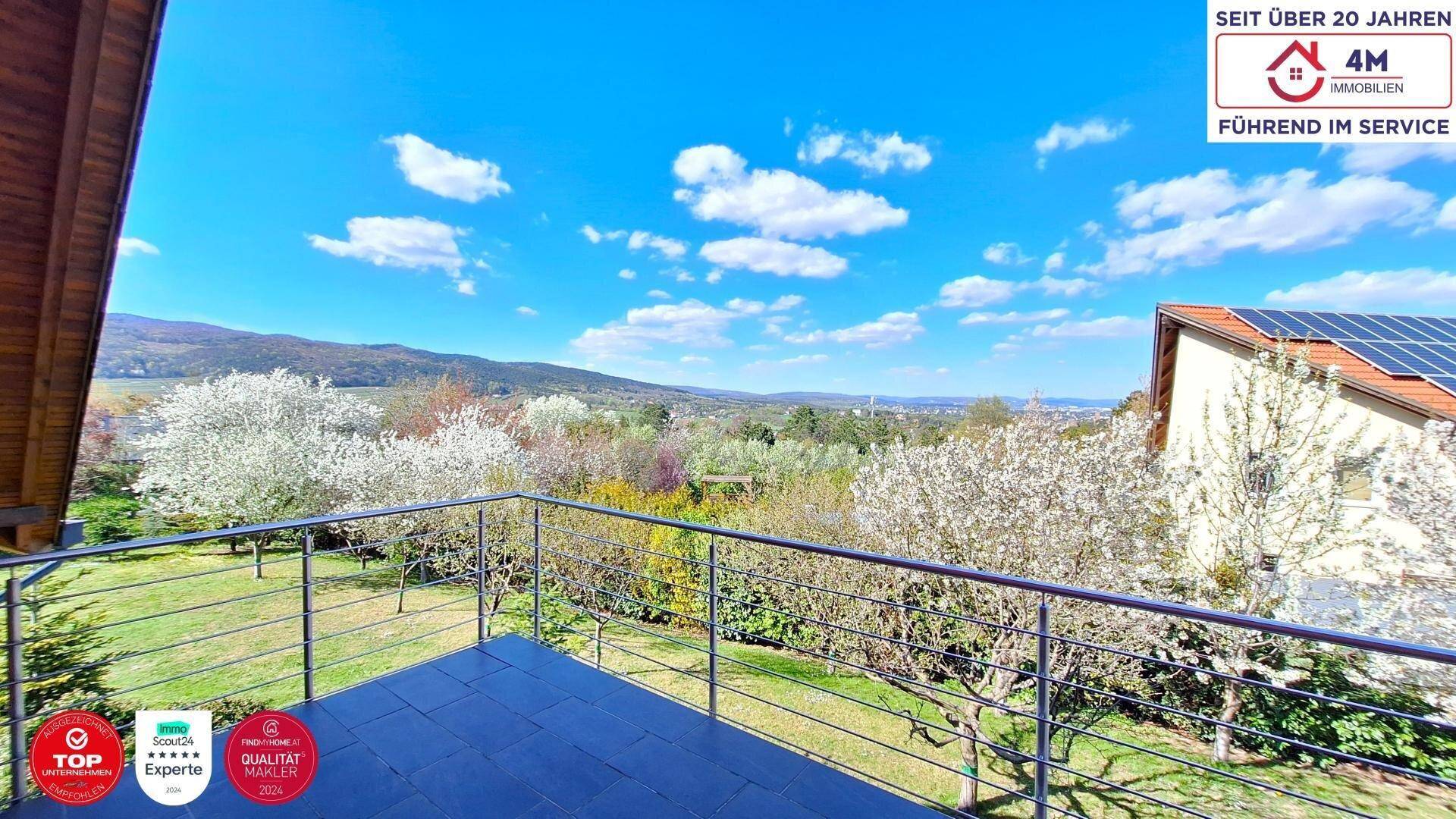 Balkon mit weitem Blick über die Landschaft und das Hausdach mit Photovoltaikanlage.