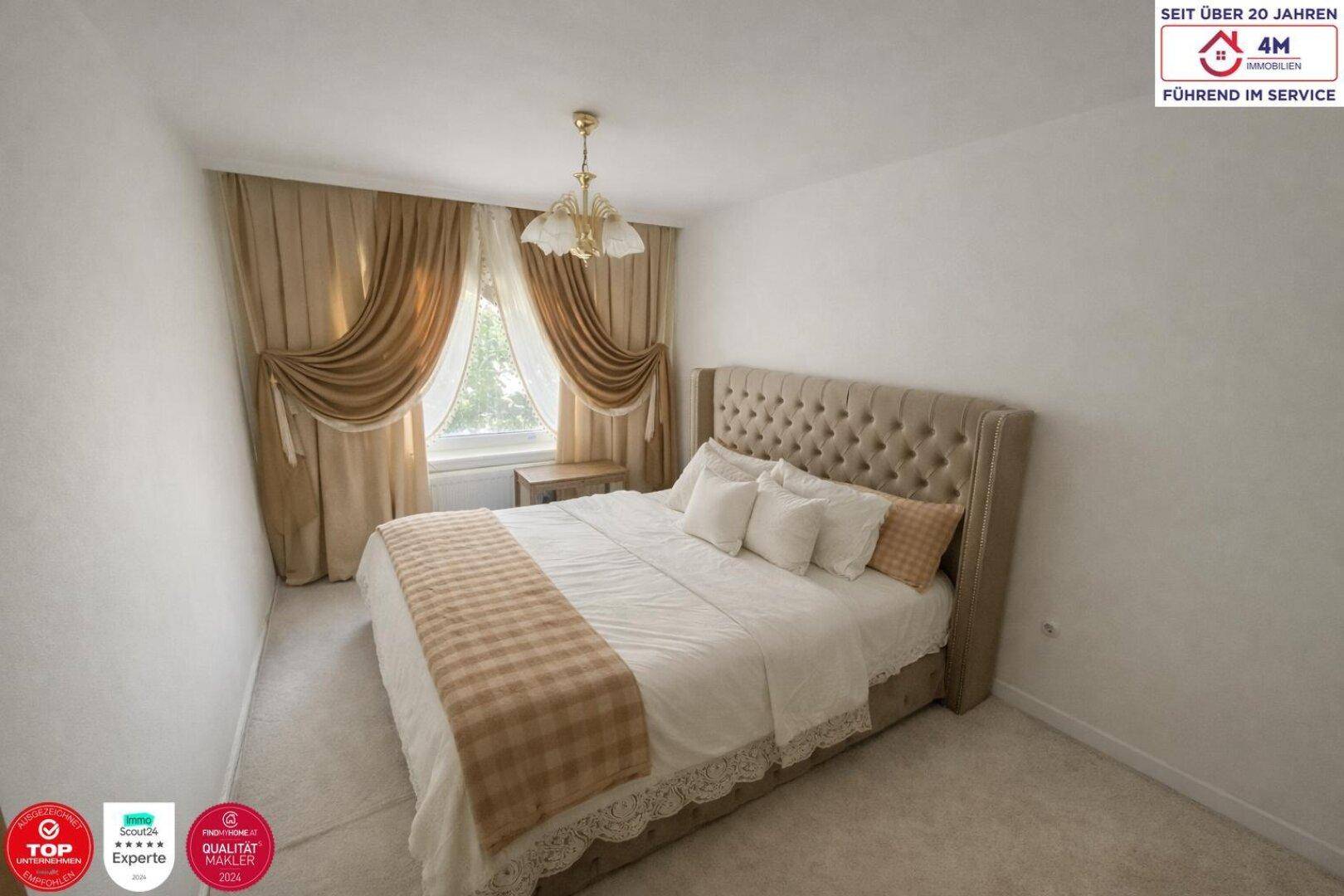 Helles Schlafzimmer mit komfortablem Doppelbett, eleganten Vorhängen und Teppichboden.