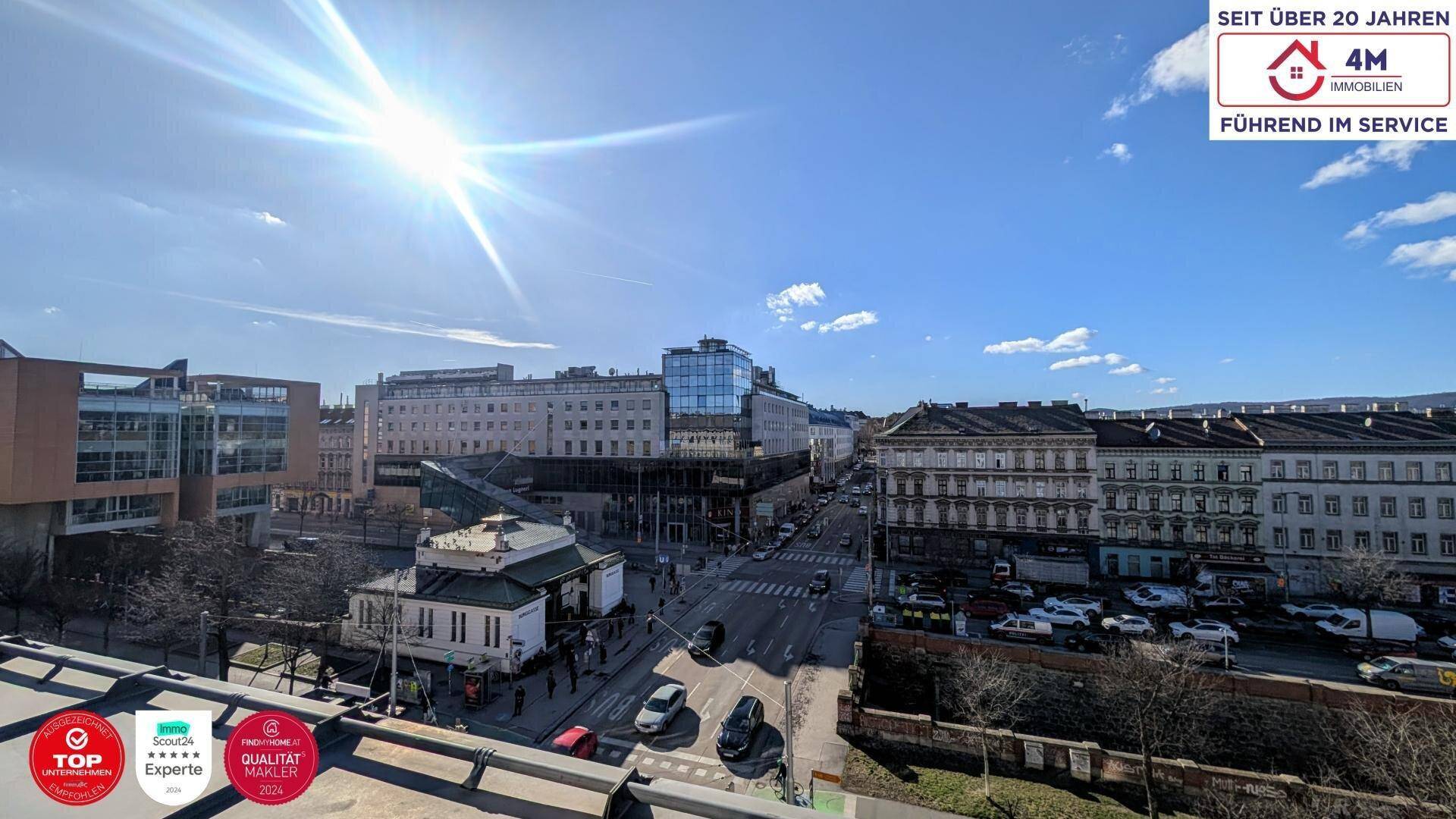 Weitblick über eine belebte Stadtstraße mit historischen Gebäuden und viel Sonnenlicht.