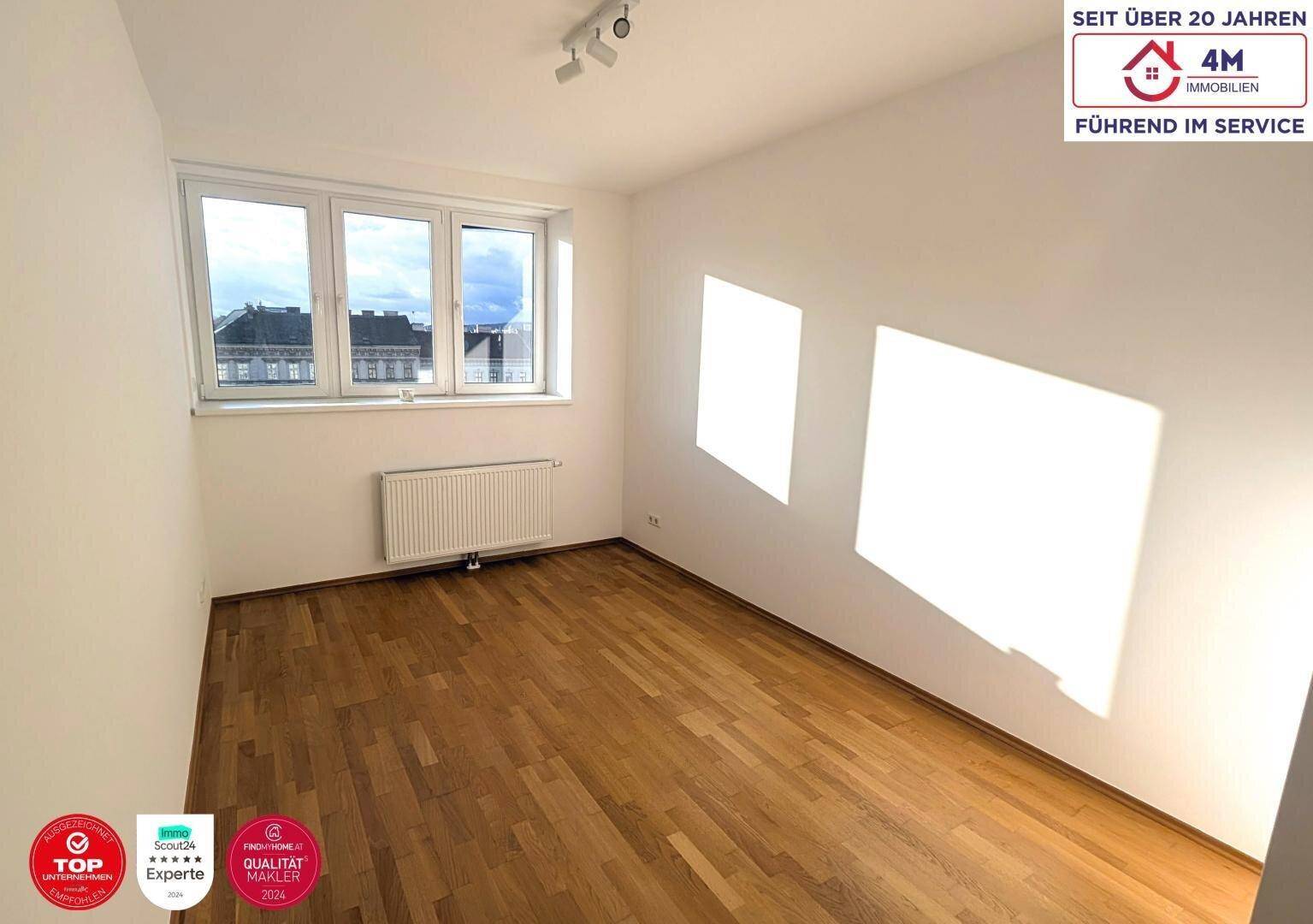 Sonniger Raum mit Parkettboden und großen Fenstern, ideal als Schlaf- oder Arbeitszimmer.