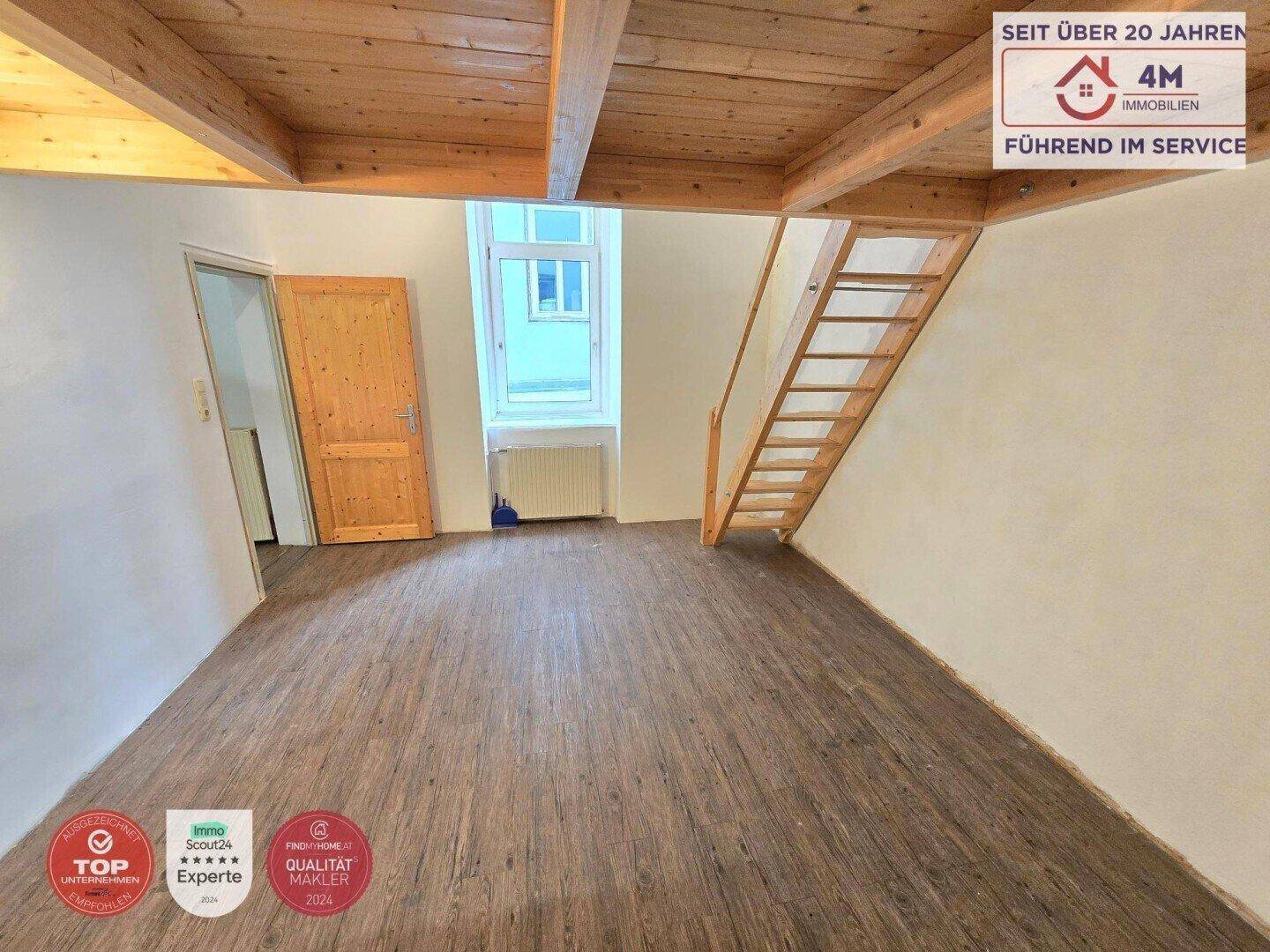 Geräumiger Raum mit Laminatboden, Holzbalkendecke und Holztreppe zum Obergeschoss.