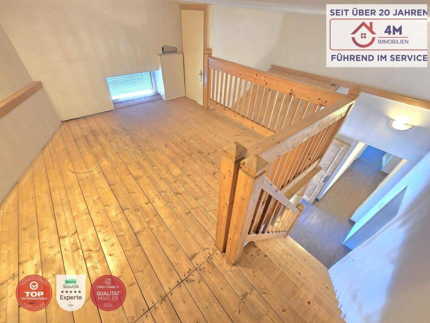 Offener Dachbodenbereich mit Holzdielenboden und Holzgeländer, ideal für individuelle Gestaltung.