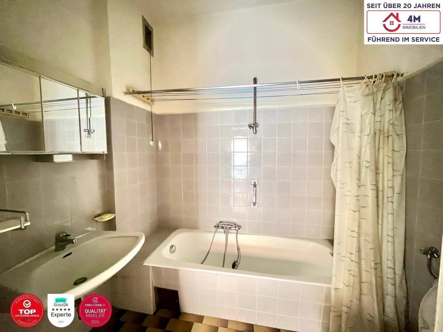 Badezimmer im Stil der 80er Jahre mit Badewanne, Waschbecken und Fliesen, funktional und gepflegt.