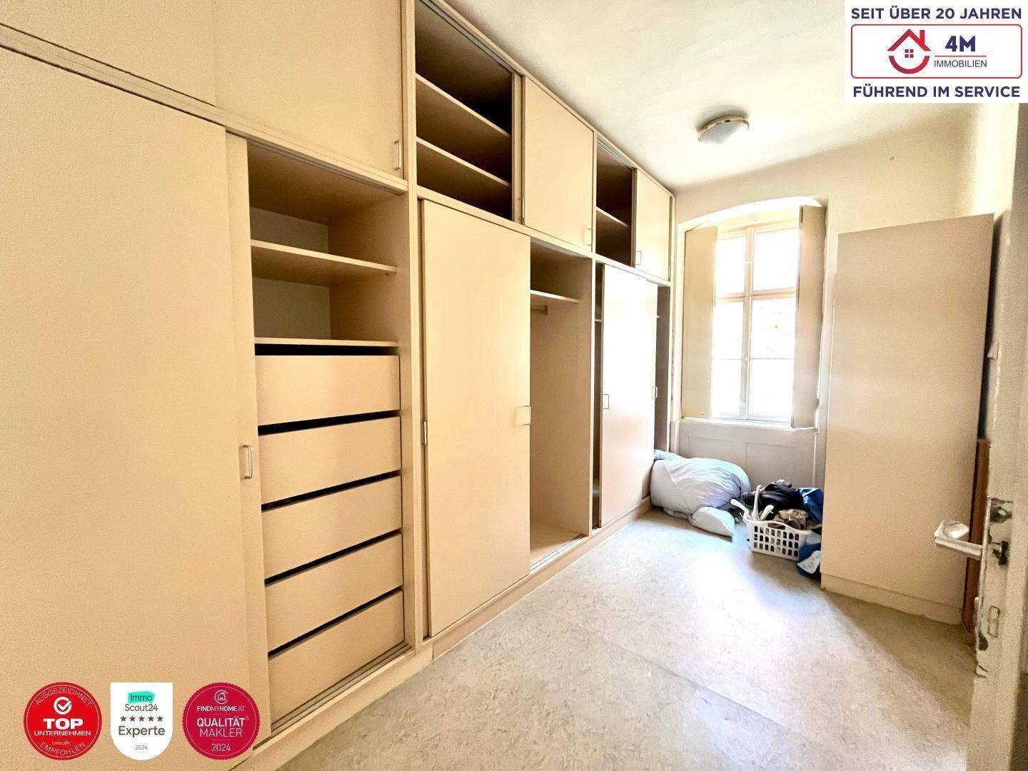 Schlafzimmer mit großzügigen Einbauschränken und Fenster für Tageslicht, bietet viel Stauraum.
