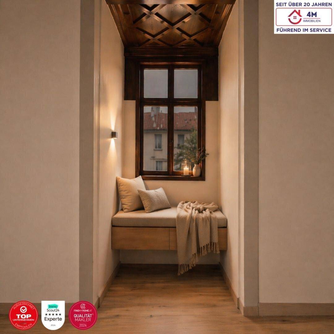 Gemütliche Fensternische mit Sitzbank, Kissen und dunkler Holzdeckenverkleidung, ideal zum Entspannen.