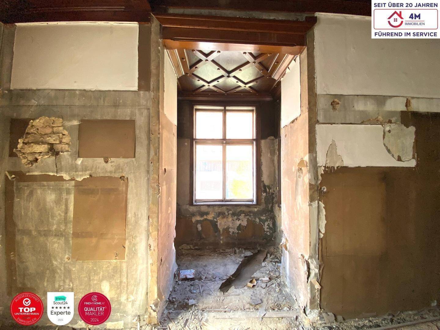 Renovierungsbedürftige Nische mit Fenster und aufwendiger Holzdeckenverkleidung, viel Potenzial.