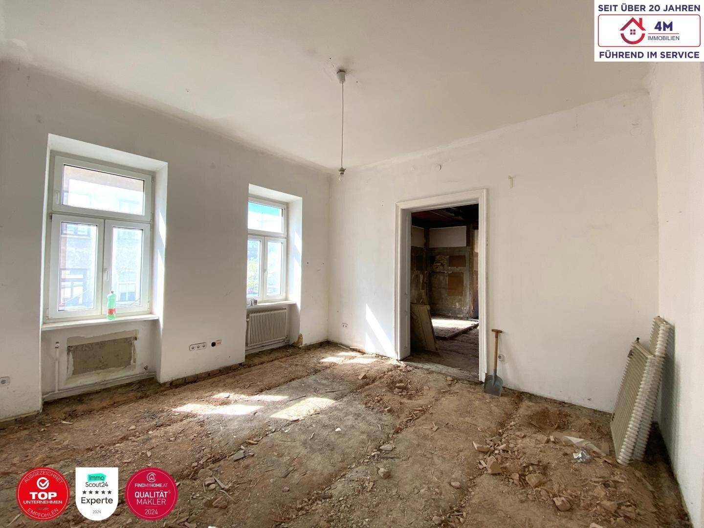 Schlafzimmer im Rohzustand mit hohen Fenstern und freiem Blick, bereit zur individuellen Gestaltung.