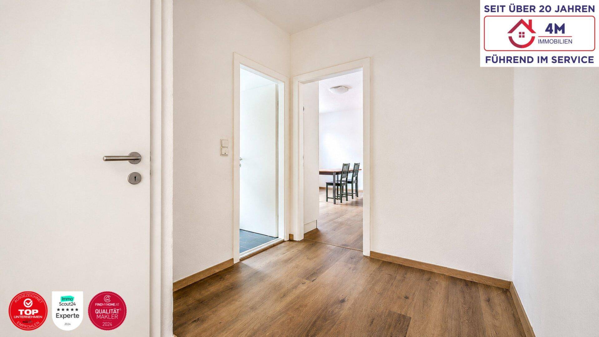 Heller Flur mit Holzboden und Zugang zu weiteren Zimmern der Wohnung.