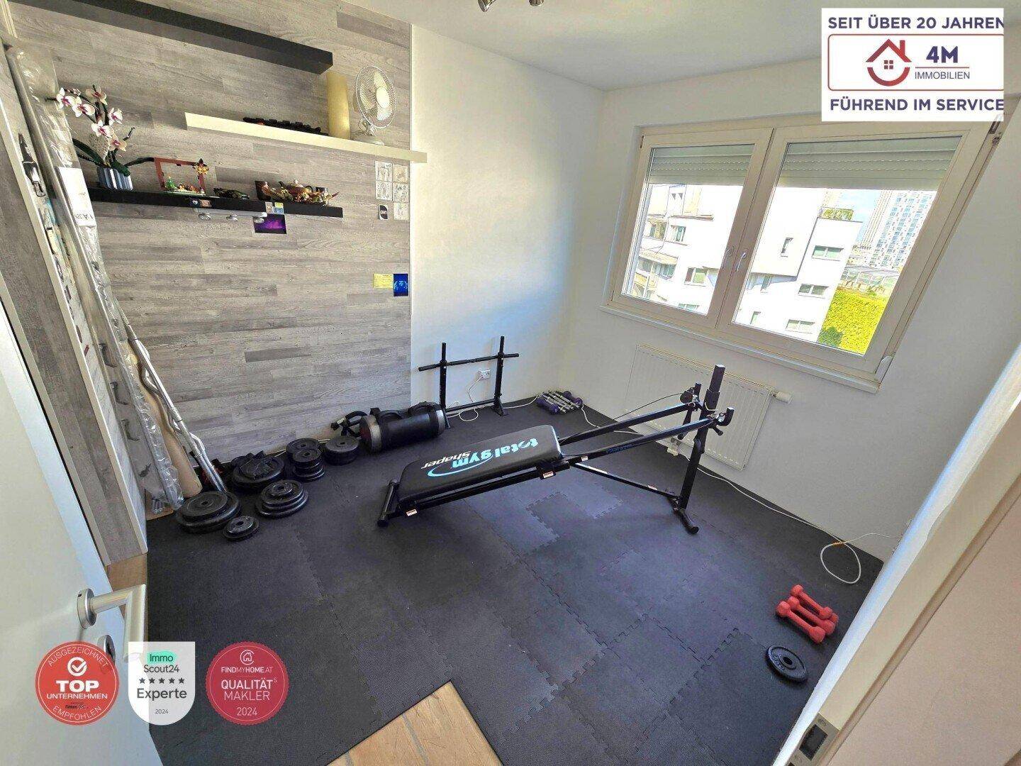 Fitnessraum mit verschiedenen Trainingsgeräten und speziellem Bodenbelag für Sportaktivitäten.