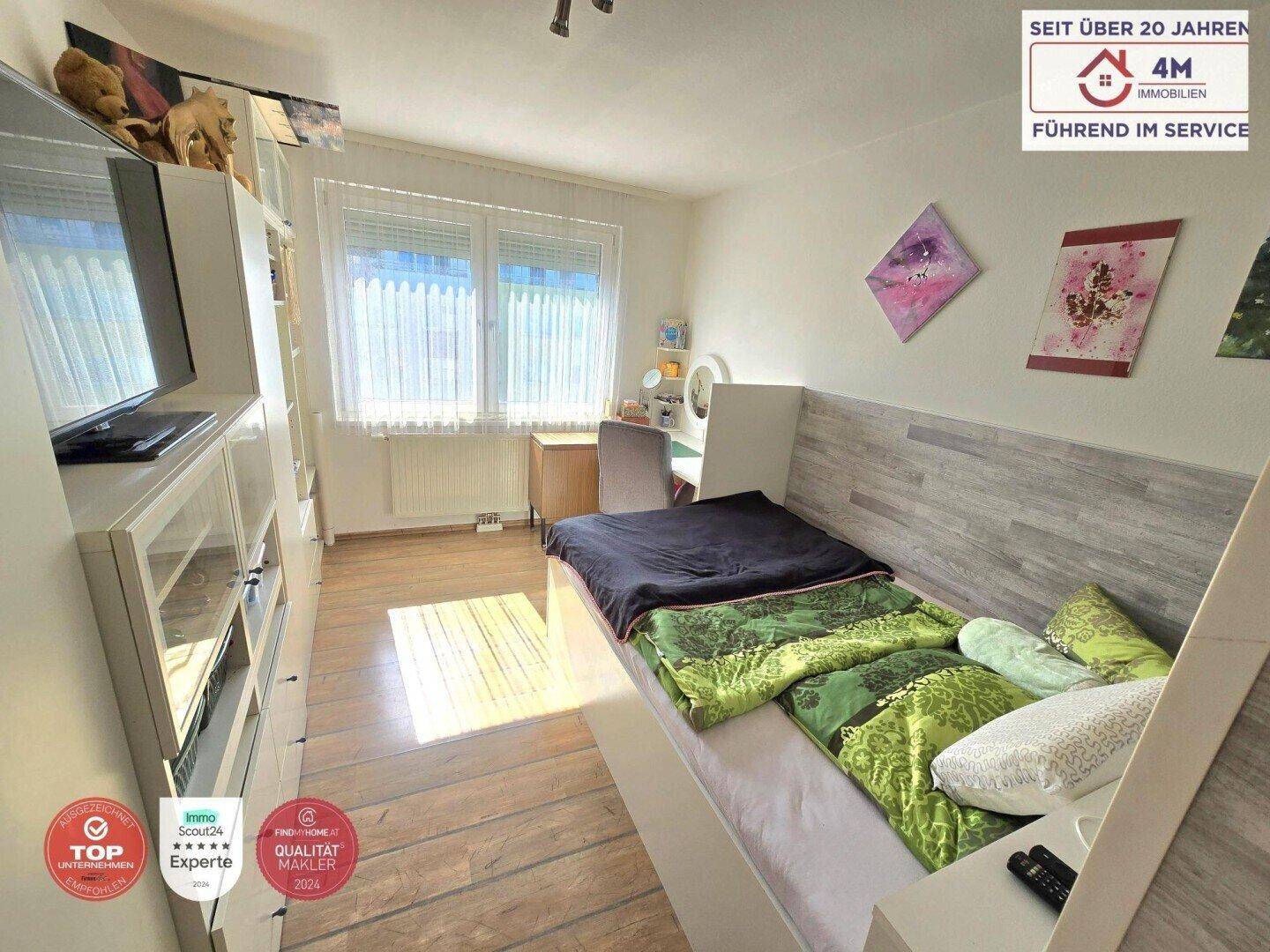 Gemütliches Kinderzimmer mit Einzelbett, Schreibtisch und Fenster für ausreichend Tageslicht.