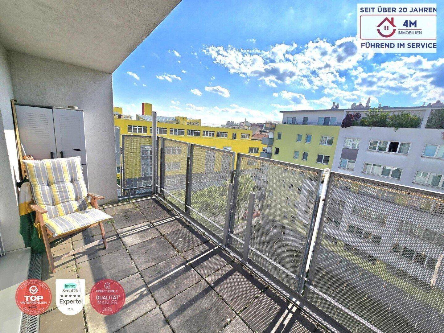 Geräumiger Balkon mit Sitzgelegenheiten und Blick auf die umliegenden Gebäude.