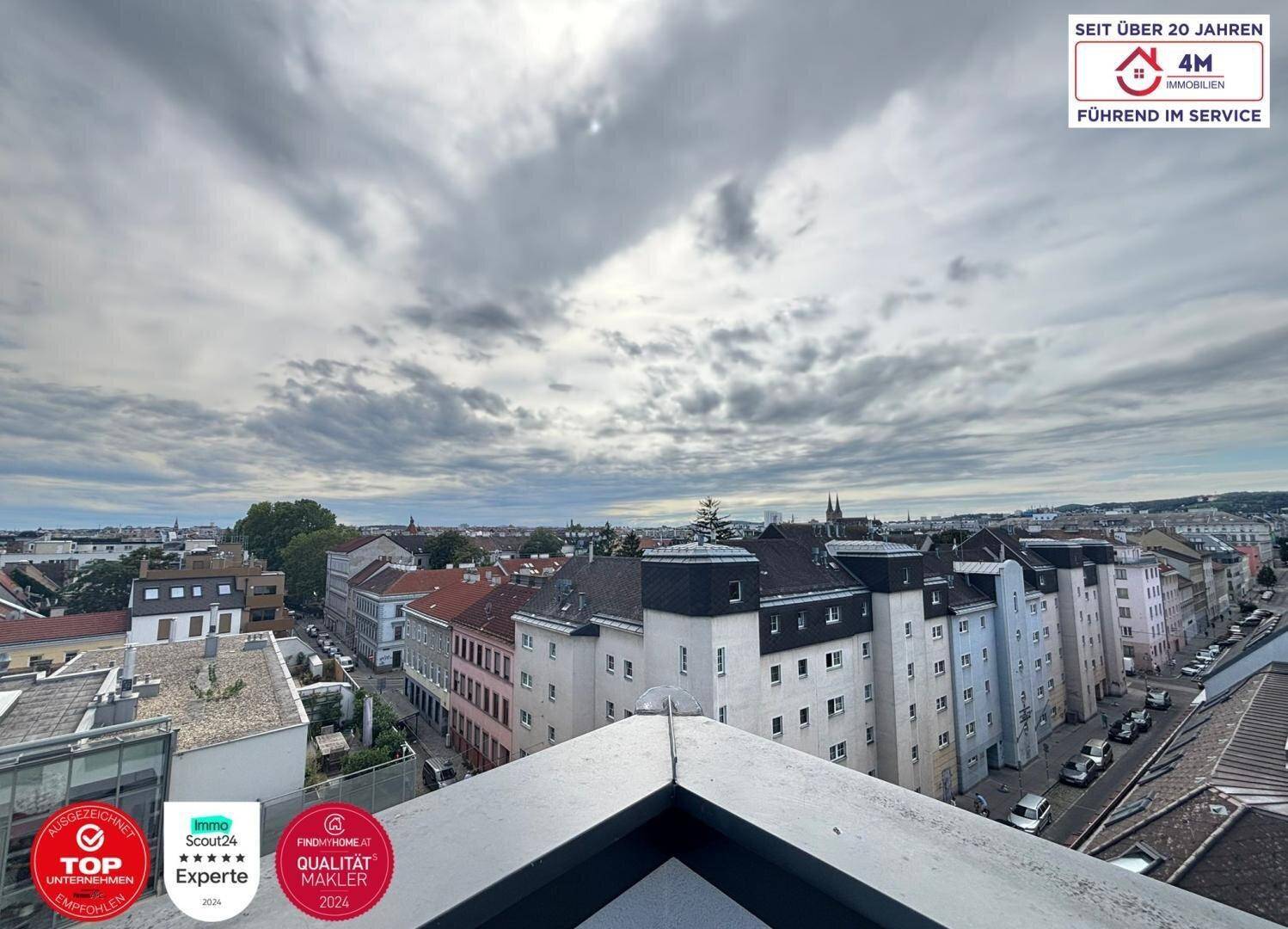 Blick über die Dächer der Stadt mit einer belebten Straße und vielen Gebäuden.