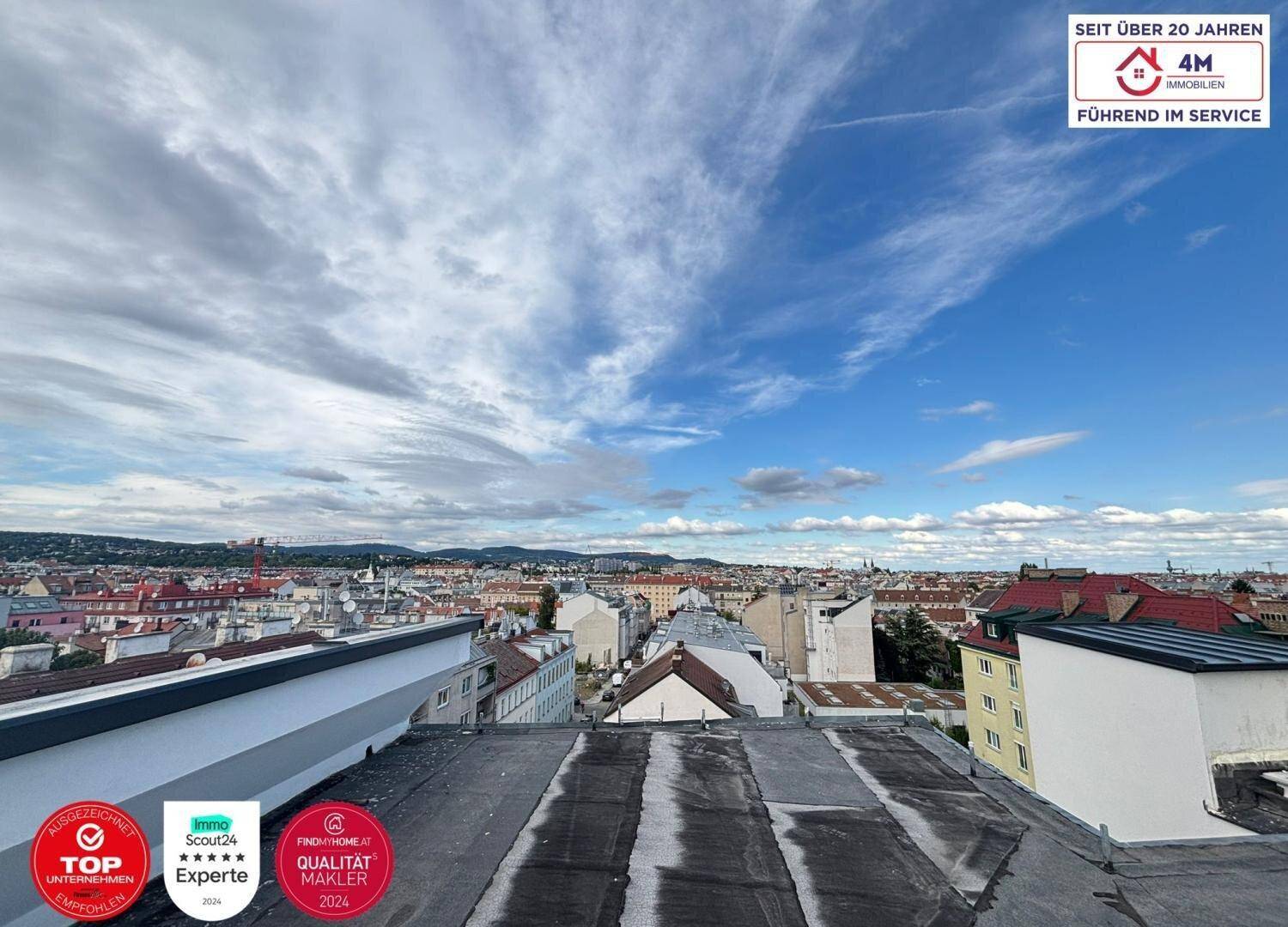Weitläufiger Blick über die Dächer der Stadt mit einem bewölkten Himmel.