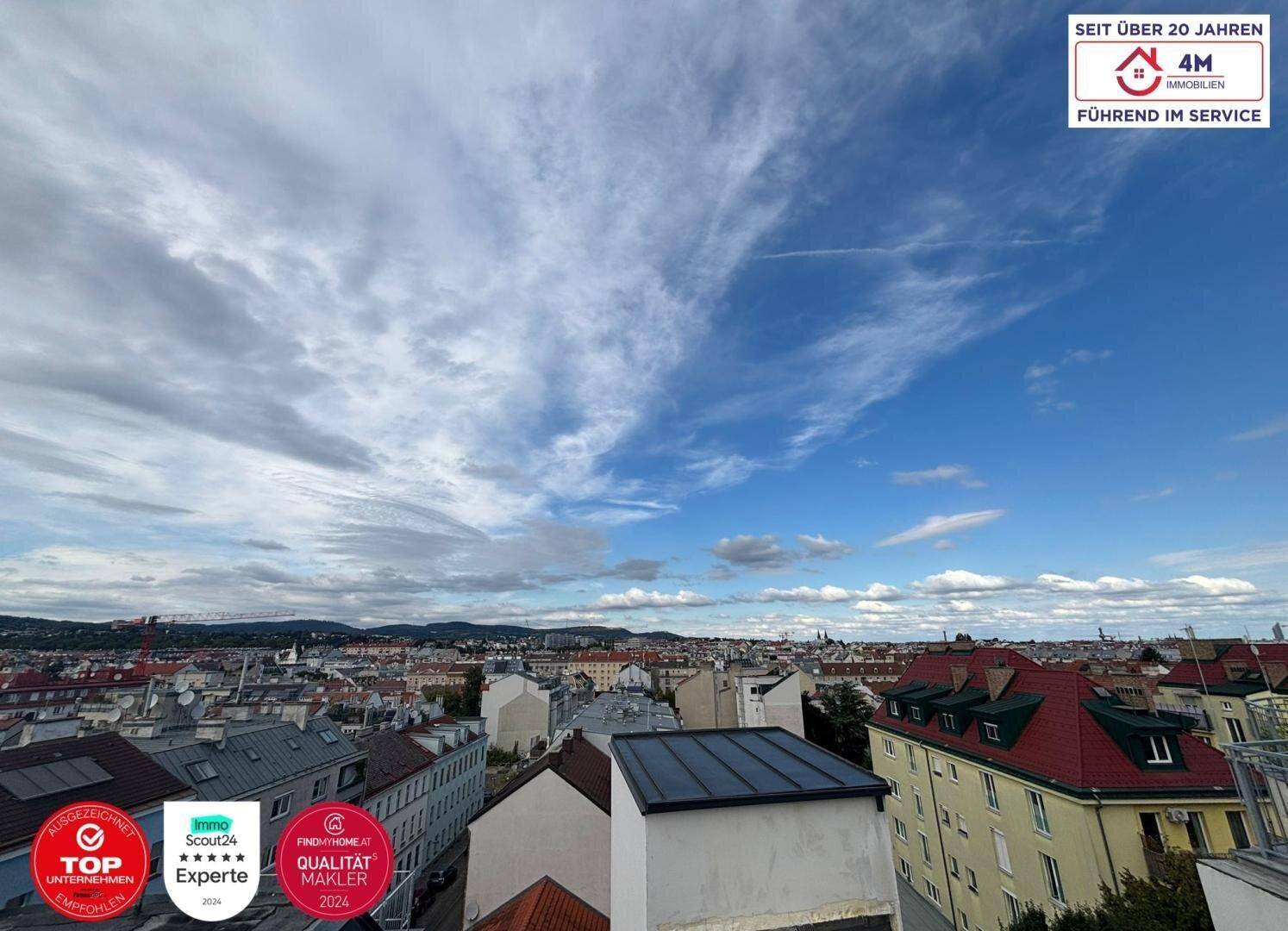 Panoramablick über die Stadt mit vielen Dächern und einem weiten Himmel.
