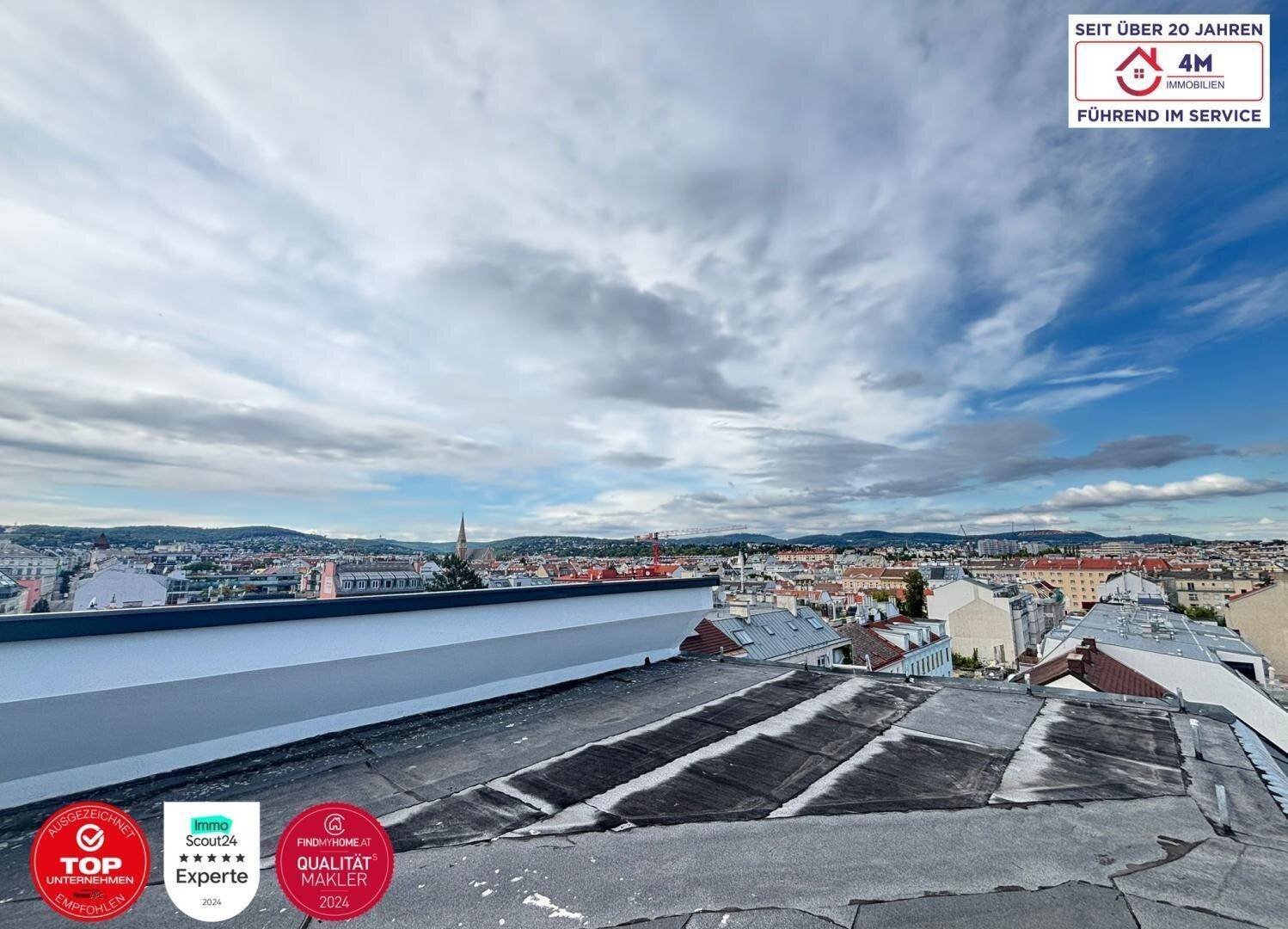 Weitläufiger Blick über die Dächer der Stadt unter einem bewölkten Himmel.
